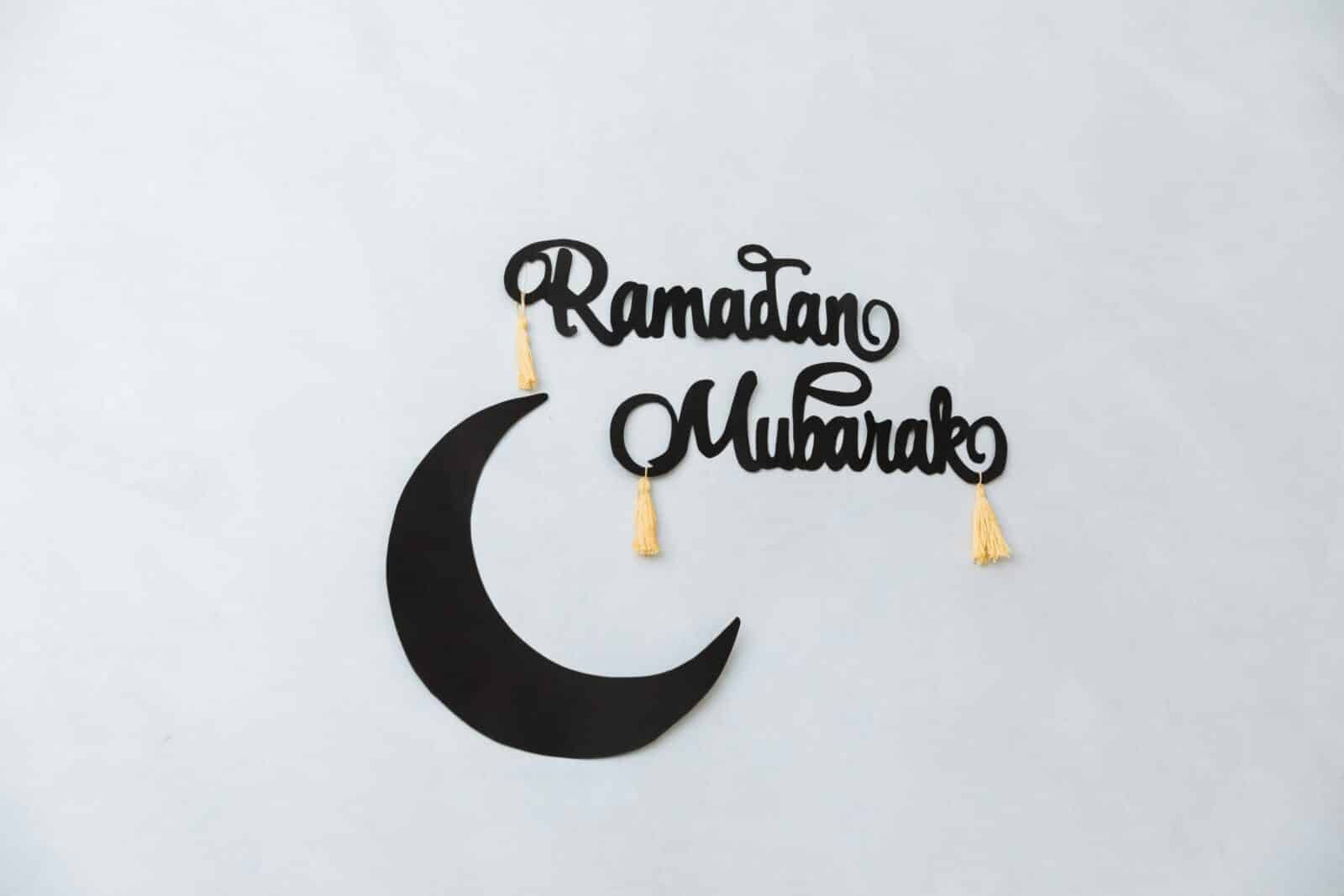 Minimalist Ramadan Mubarak decoration with crescent on a light wall background.