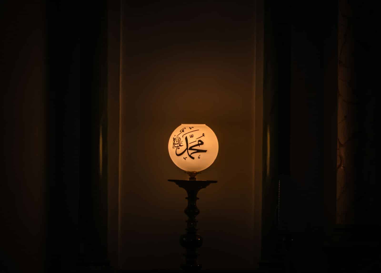 A glowing orb with arabic calligraphy on a stand.