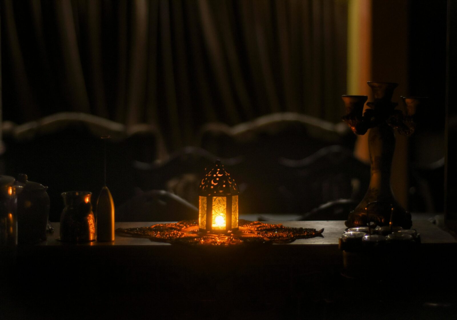 A beautifully lit lantern on a decorated table in a dimly lit room, evoking a sense of warmth and tradition.