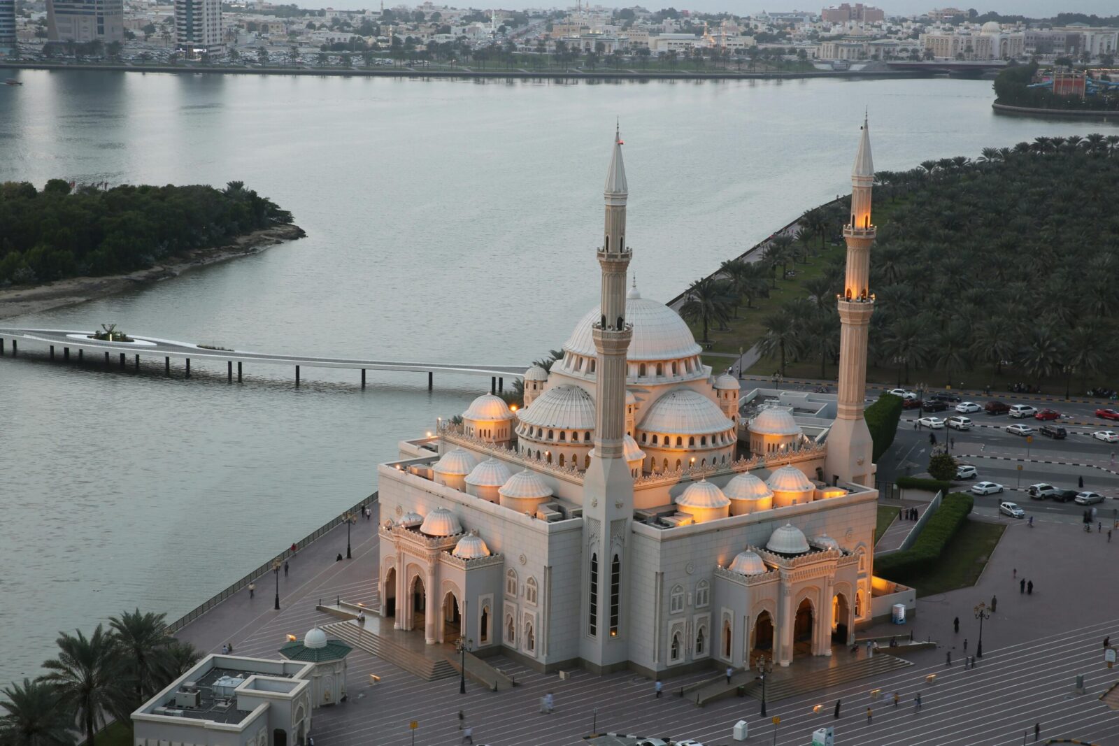 Stunning aerial view of Al Noor Mosque by the water at dusk in Sharjah, UAE.
