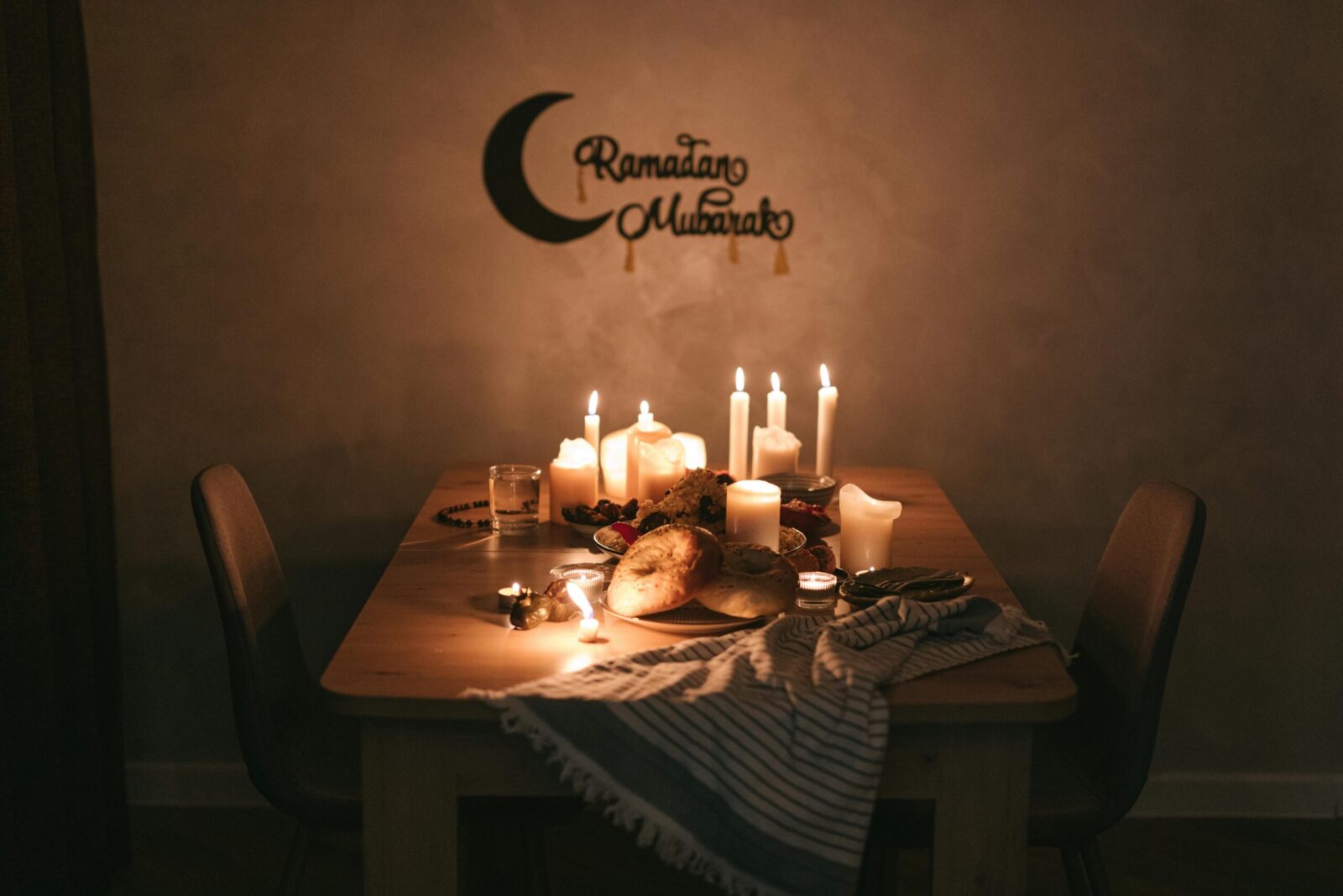 Warm and inviting Ramadan iftar table setup with candles and traditional food, perfect for evening celebrations.