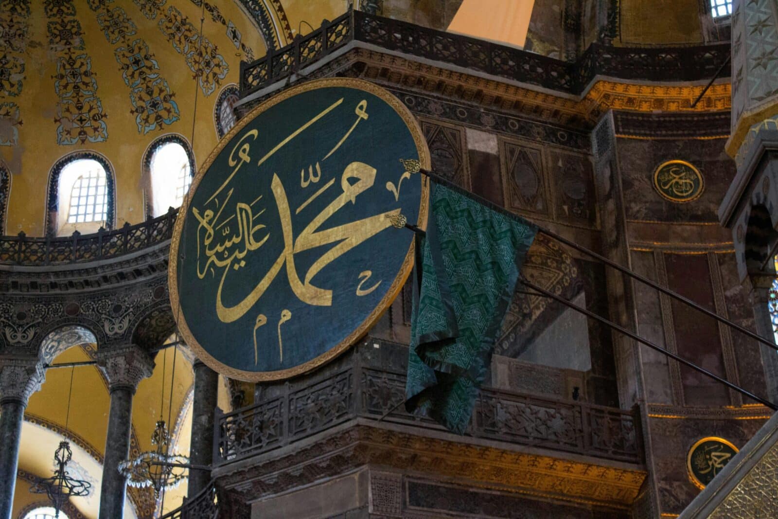 Detailed interior shot of Hagia Sophia featuring Arabic calligraphy and ornate architecture.