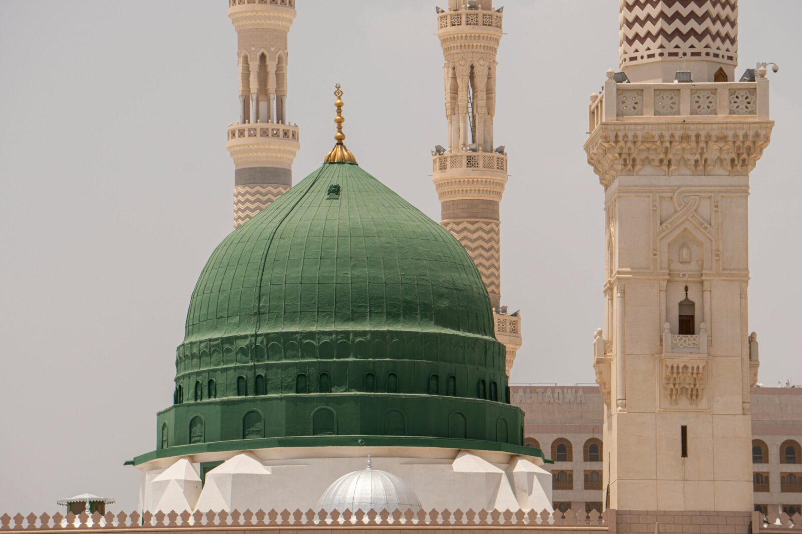 The iconic Green Dome of Al-Masjid an-Nabawi in Medina, Saudi Arabia, with surrounding minarets.