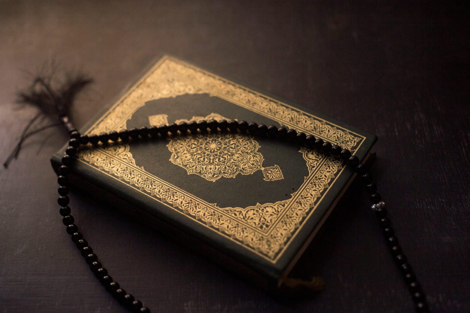 A Quran with ornate cover and prayer beads symbolizing Islamic faith.