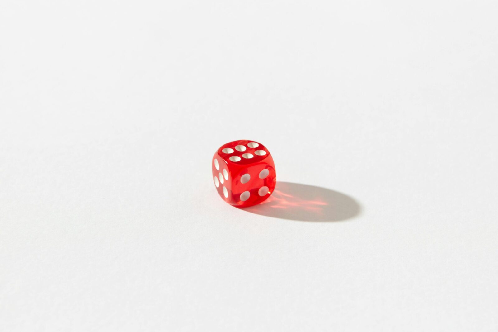 Red dice with white dots on a plain white background, highlighting simplicity and chance.